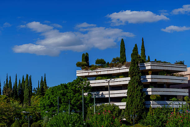 istock Modern building in Athens with rooftop garden and tall cypress trees 2247467267