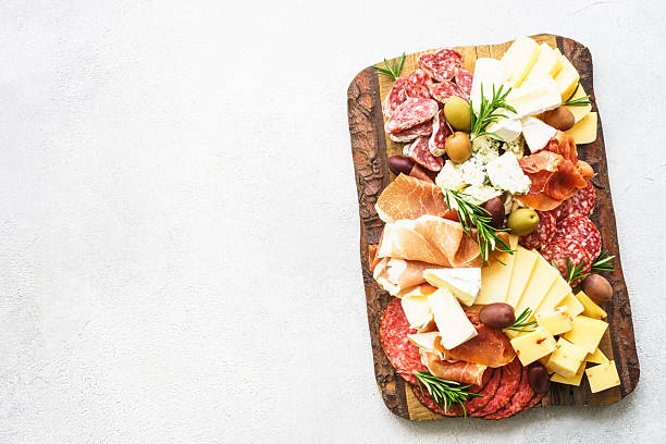 istock Cheese and meat - jamon, salami, olives at marble table. 2247469006