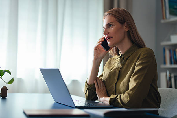 istock Professional Woman Working At Home Office On Phone With Laptop And Documents 2247473790