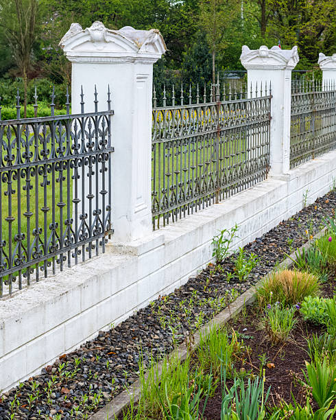 istock Wrought iron fence protecting lush green garden in spring 2247474754