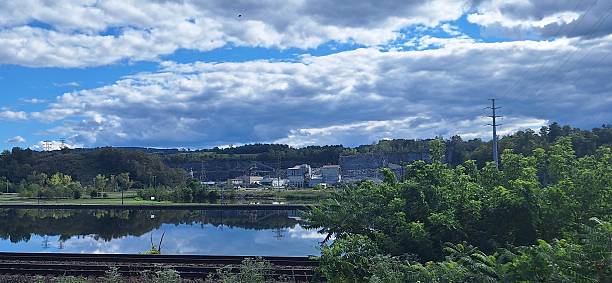An old rustic factory sitting on a riverbank in upstate New York with dramatic skies.