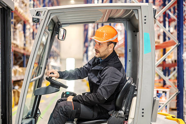 istock Employee operating forklift in large distribution warehouse 2247485279