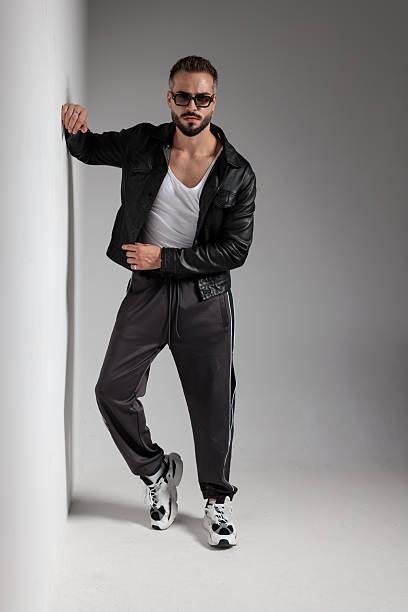 istock sexy unshaved man in black leather jacket leaning arm on wall 2247486324