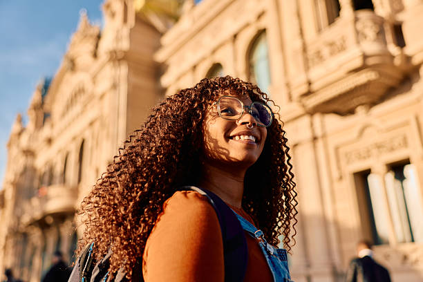 istock Smiling young woman exploring city architecture on sunny day 2247486360