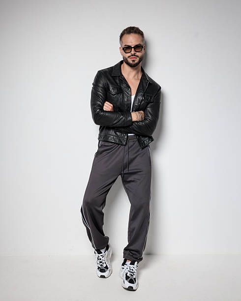 istock cool fashion man in black leather jacket crossing arms and looking forward 2247486983