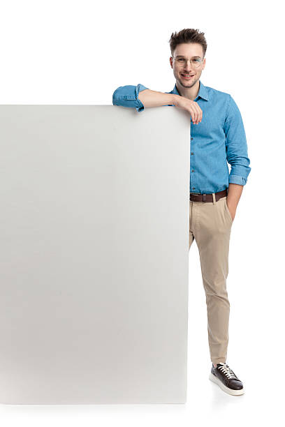 istock Happy casual man with glasses leaning on billboard 2247487978