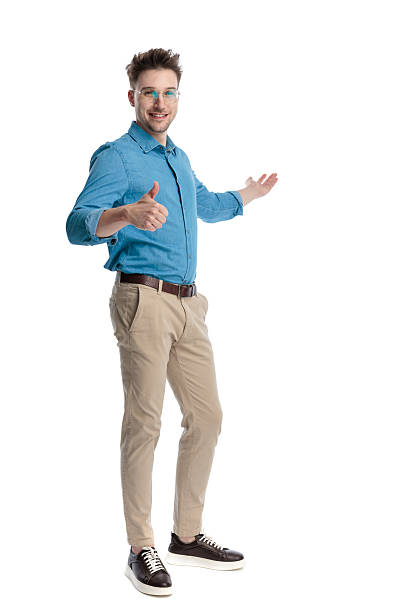istock Happy casual man presenting and making thumbs up 2247488527