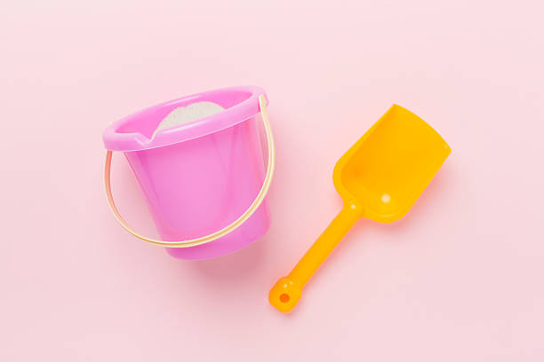 Cute toys for playing with sand on color background, top view