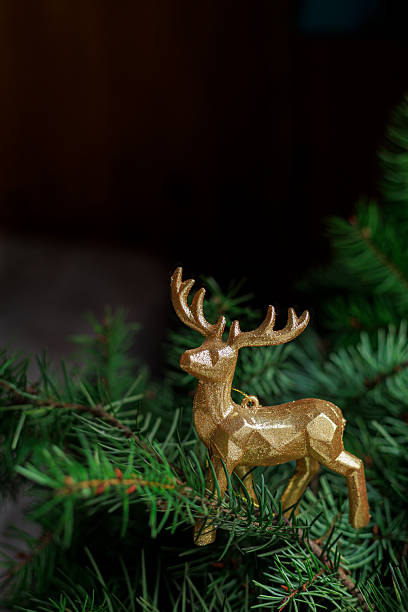 istock Golden reindeer figurine on fir branches 2247490586