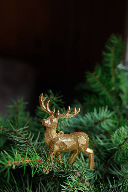 istock Golden deer ornament on spruce branch 2247490618