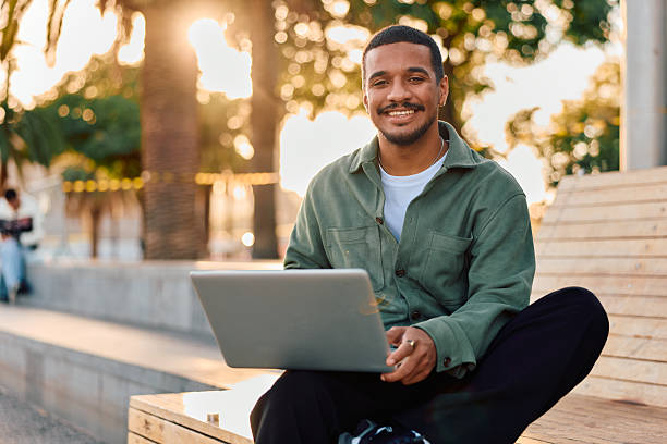 istock Young adult man working laptop outdoors smiling 2247490905