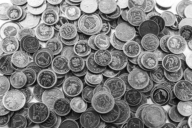 A black and white full-frame composition of Polish grosz coins randomly scattered, producing a high-contrast metallic texture ideal for abstract and financial themes.