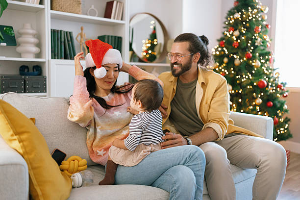 istock Parents Playing with Baby in Front of Christmas Tree at Home 2247500520