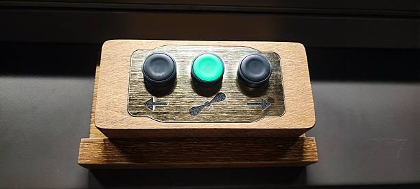 istock A child's hands grip a small wooden control panel with three buttons. Concepts include child development, tactile learning, technology for children, hand-eye coordination, and interactive exhibits. 2247502615