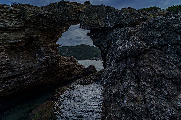 istock Dark sea arch in rugged coastal cliffs 2247505520