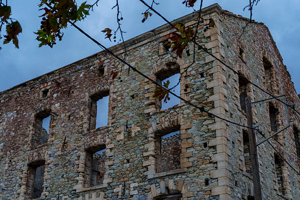 Low angle view of an abandoned building once used as an asylum hospital on a cloudy stormy day, West Virginia