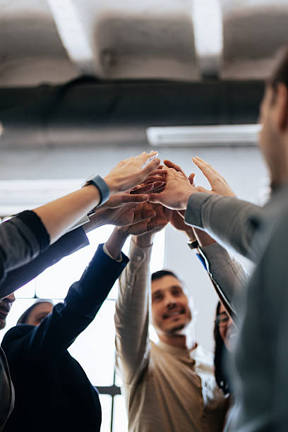 istock Group Of Diverse Professionals Join Hands In A Celebration Of Teamwork And Collaboration 2247507138