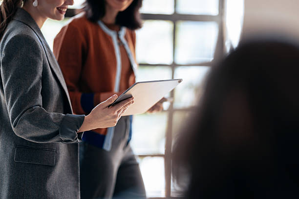 istock Professional Women In A Modern Office Discussing Ideas With Tablet In Hand 2247507187