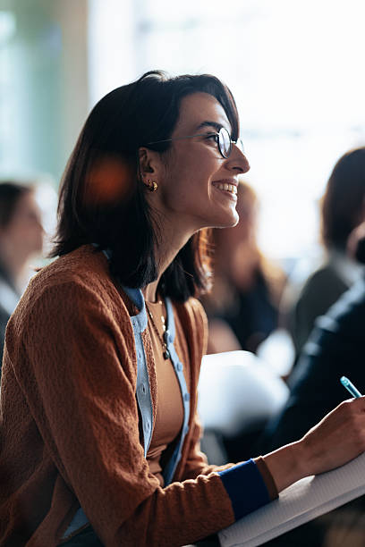 istock Smiling Woman In Glasses Taking Notes During A Collaborative Business Meeting 2247507284
