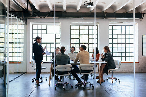 istock Professional Team Meeting In A Modern Conference Room With Presenter Standing And Group Discussion 2247507305