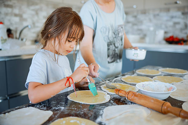 istock Grandma and granddaughter stretching dough 2247508410