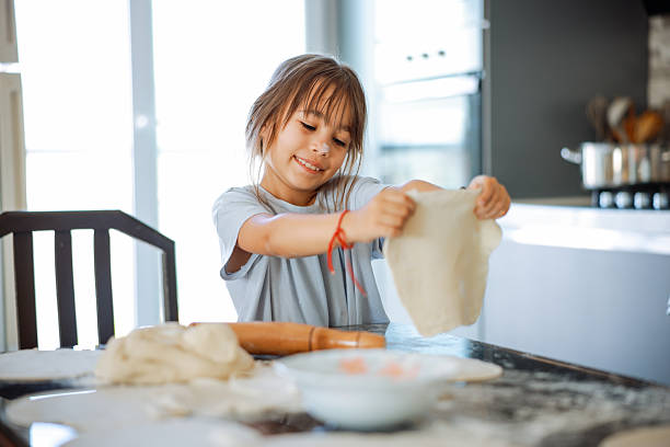 istock Grandma and granddaughter stretching dough 2247508627