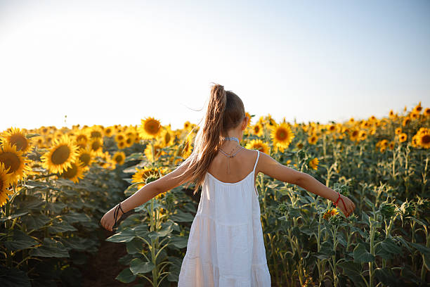 istock Child playing in sunflower field on sunny summer day 2247508678