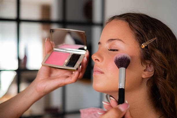 istock Makeup artist applying blush on young woman's cheek 2247510734