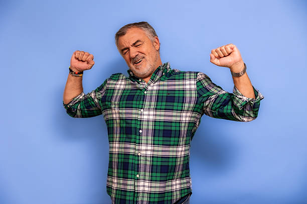 istock Senior man waking up stretching feeling tired and relaxed 2247511541