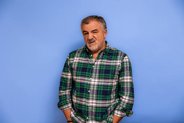 istock Mature adult man winking grimacing face blue background 2247511549