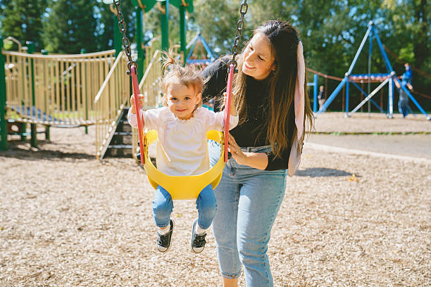 istock Happy mother with two year sit on the swing 2247512305