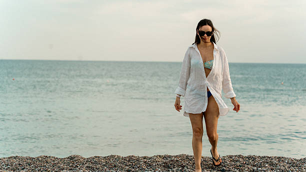 istock Happy Woman Walking on Pebble Beach 2247521420