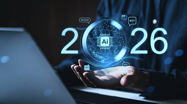istock Futuristic AI concept with digital brain and 2026 glowing numbers over open hands in front of a laptop on dark background, symbolizing future technology online. 2247521816