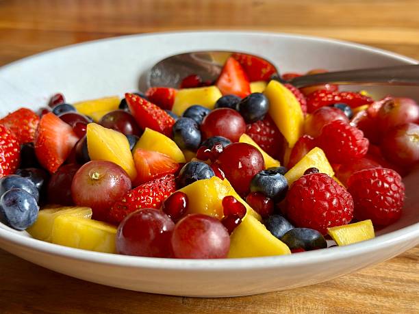 istock A selective focus view of mixed fruit in a bowl with a spoon on a wooden table. Vegetarian or vegan food. 2247521880