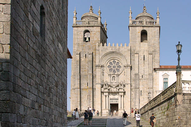 Porto, Portugal - June 08 2025: Majestic cathedral with intricate stone details and towering spires, viewed from the base of the grand staircase, highlighting architectural elegance and grandeur