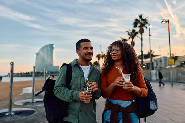istock Young couple walking along Barcelona beach at sunset 2247530952