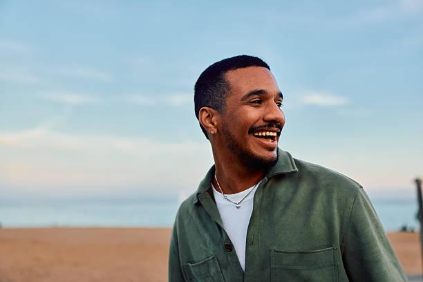 istock Happy young adult man laughing outdoors at beach 2247531365