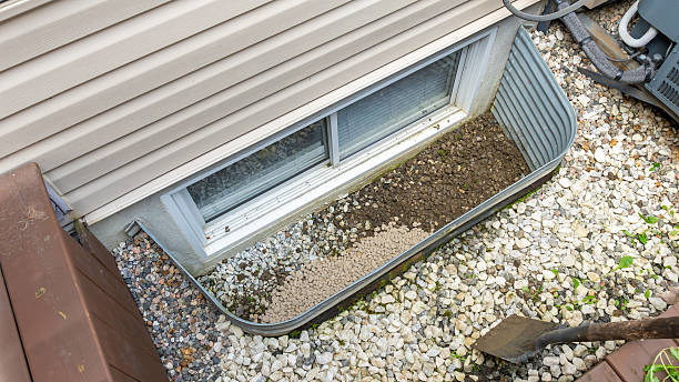 istock Gravel and soil landscaping around a basement window, showcasing drainage solutions and outdoor design elements for effective water management 2247532199