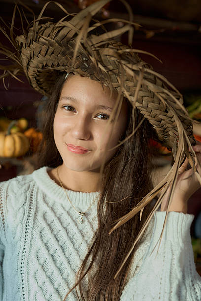 Young woman smiling, wearing straw hat and sweater