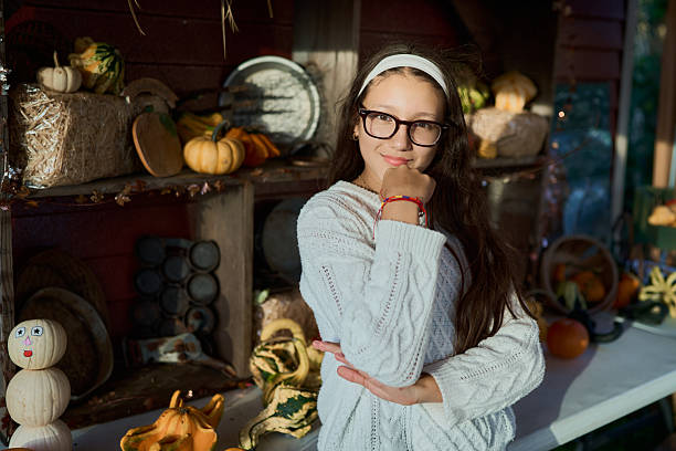 Young girl smiling surrounded by autumn harvest decorations