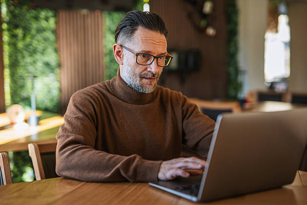 istock Caucasian man working on laptop in modern restaurant 2247533808