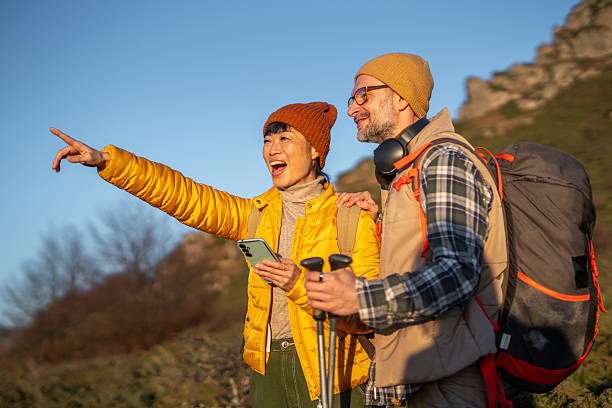 istock Couple hiking mountain trail navigating with phone 2247534339