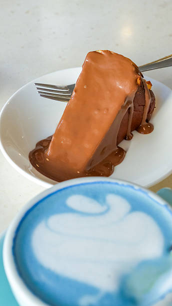 Blue matcha latte served in a stylish cup alongside a decadent chocolate dessert on a white plate, showcasing vibrant colors and inviting textures for a delightful culinary experience
