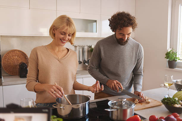 istock Happy couple cooking meal together in kitchen 2247536892