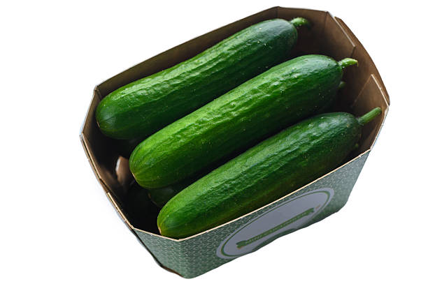 istock Mini cucumbers for sale in cardboard box on white background 2247539073