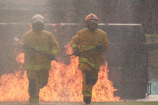 istock Firefighters running through flames with axes during a dangerous emergency. 2247539089