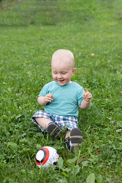 istock Happy baby boy playing with a ball in a park. 2247539177