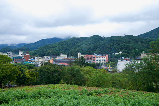 Suanbo Township fills a narrow valley below wooded slopes near Chungju, with low clouds on the foothills and hotels and bathhouses lining the streets.