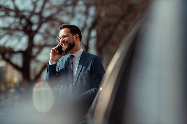 istock Businessman Talking on Phone by Car 2247542684