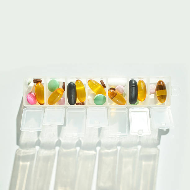 istock Daily pill organizer with various multicolored capsules and tablets for health 2247543230